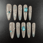 51 - Noah-UlightBlue glitter oval nails with aqua rhinestones and star-shaped gems