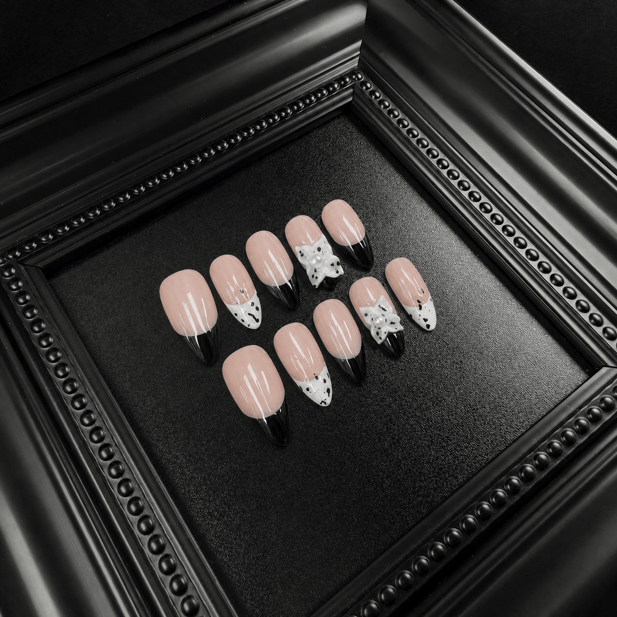 Nude-pink press-on nails with black French tips and white star details