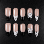 Black and white French tip press-on nails with a 3D pearl bow