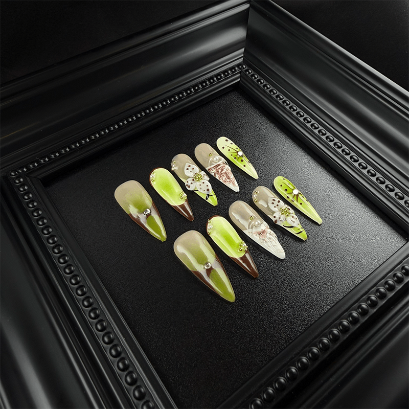 Extra long matcha green stiletto nails with marble and pearl details