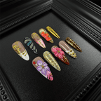 Nude stiletto nails with gold swirls and butterfly details
